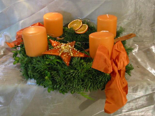 Adventskranz mit orangefarbenen Kerzen